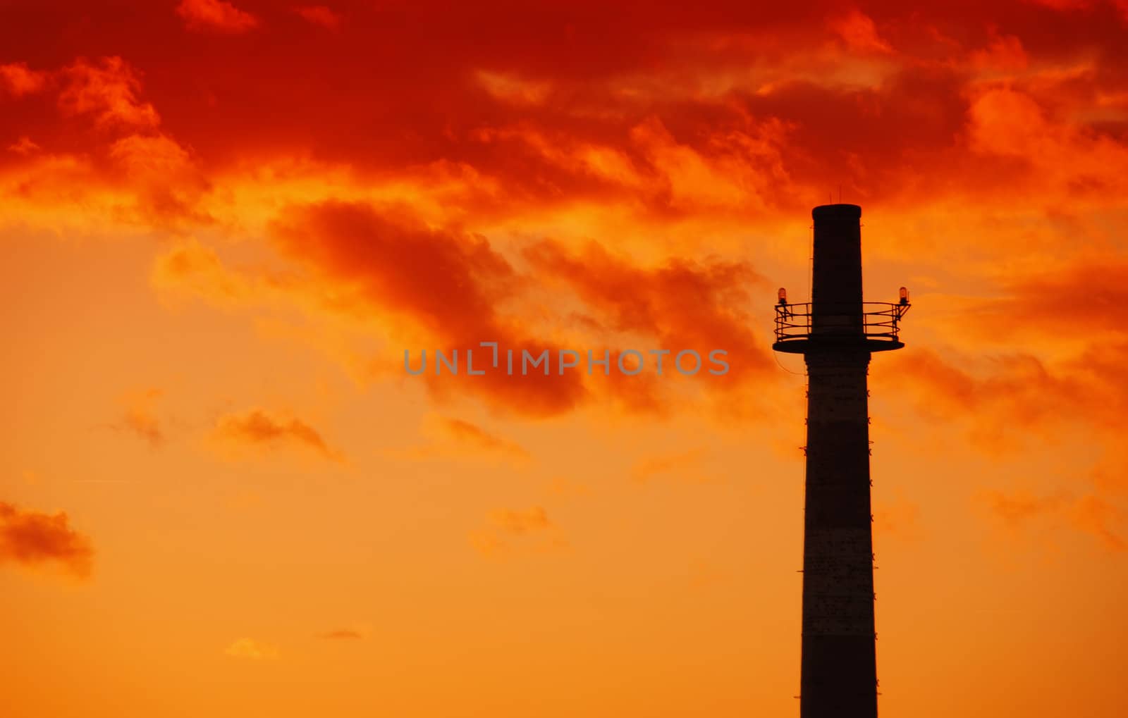 Old industrial chimney sihouette at beautiful warm sunset