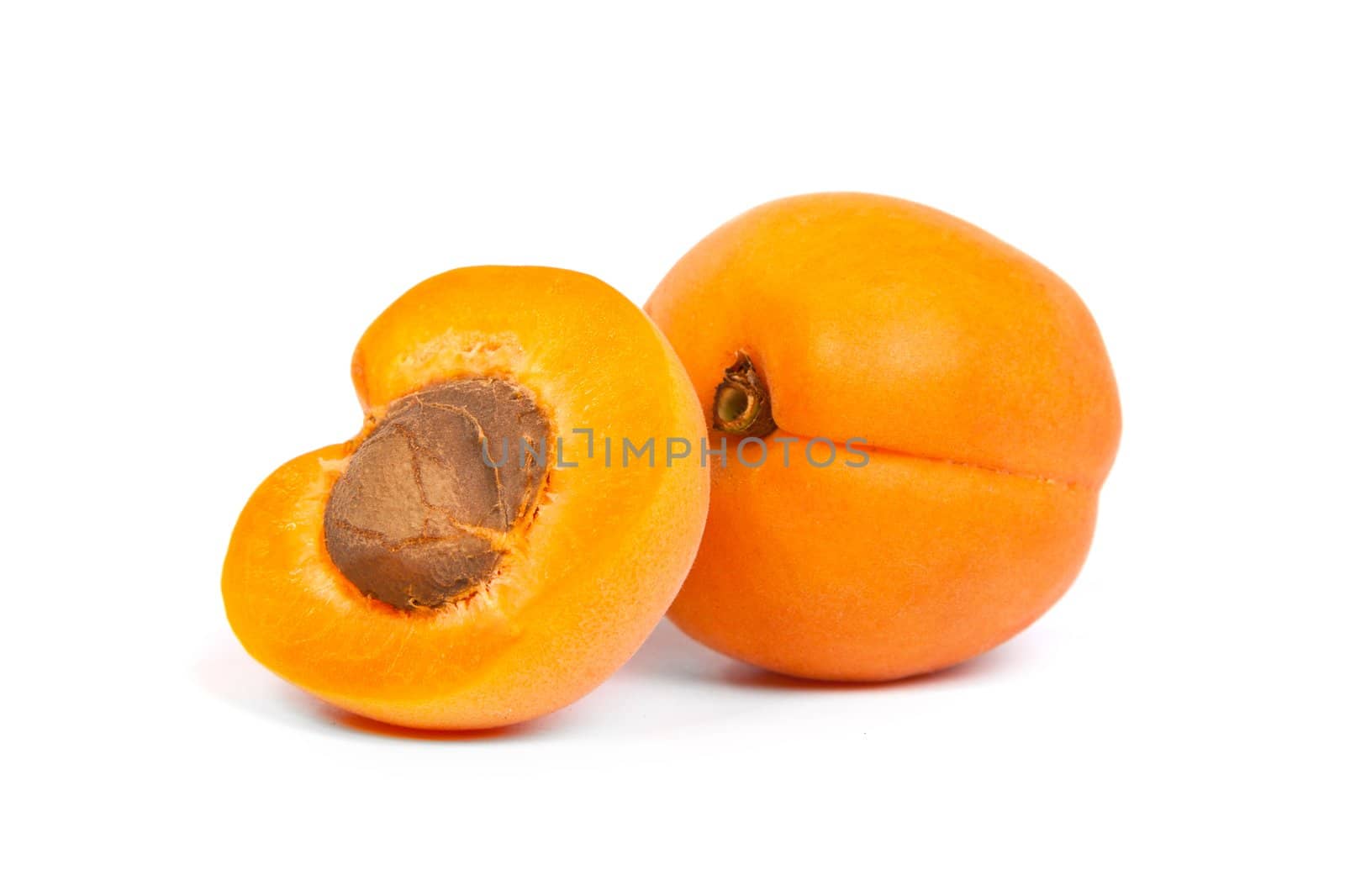 Two ripe apricot with a half isolated on a white background