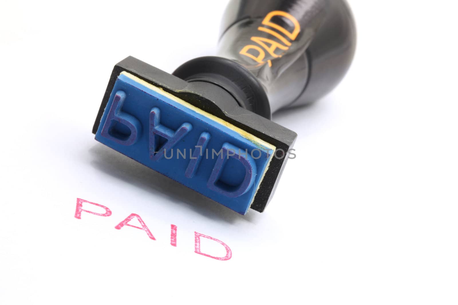 closeup of paid letter on rubber stamp isolated on white background