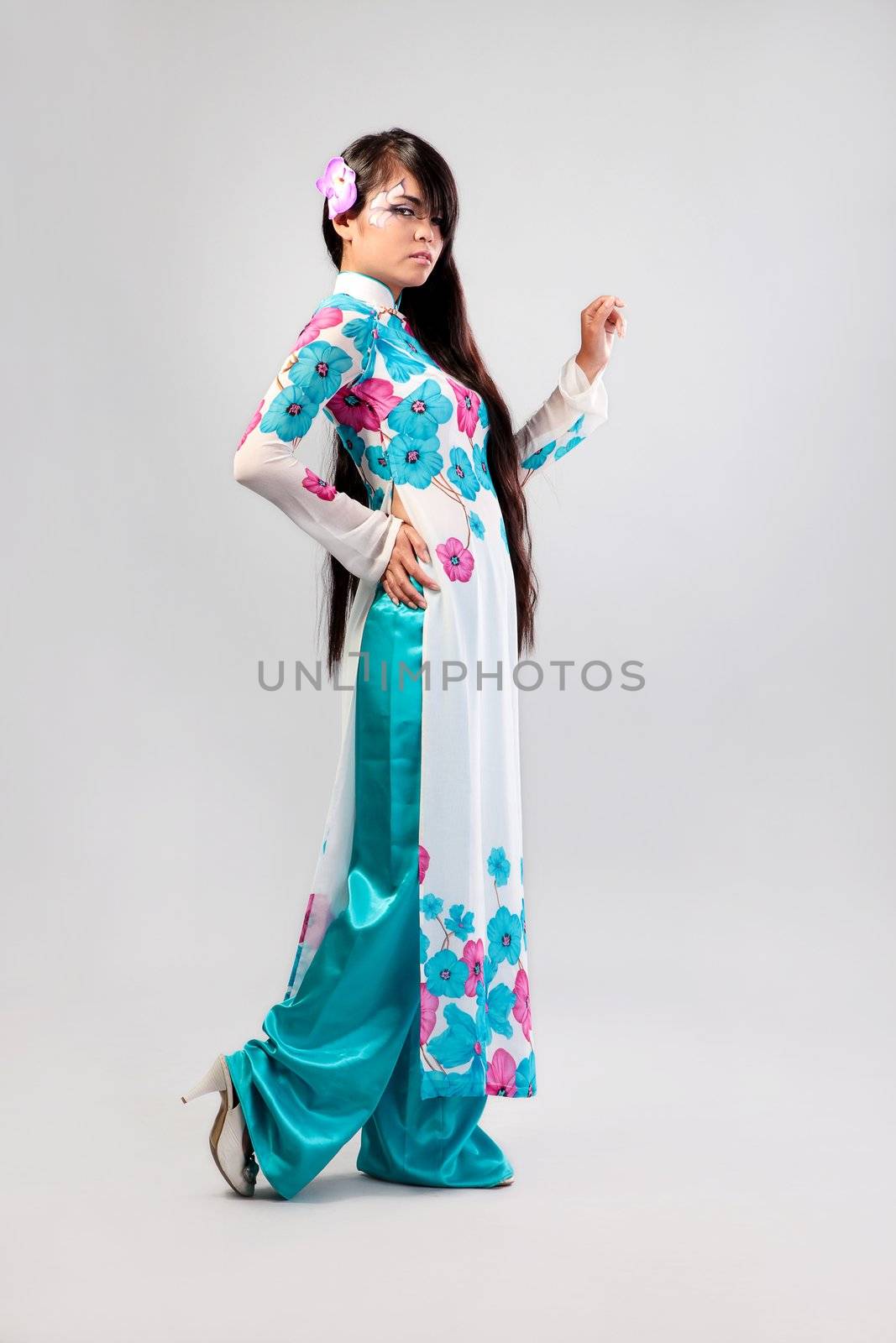 Beautiful asian woman wears a national dress isolated on a grey backround