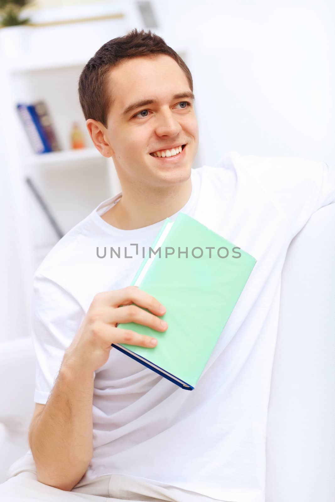 Young handsome man at home with a book