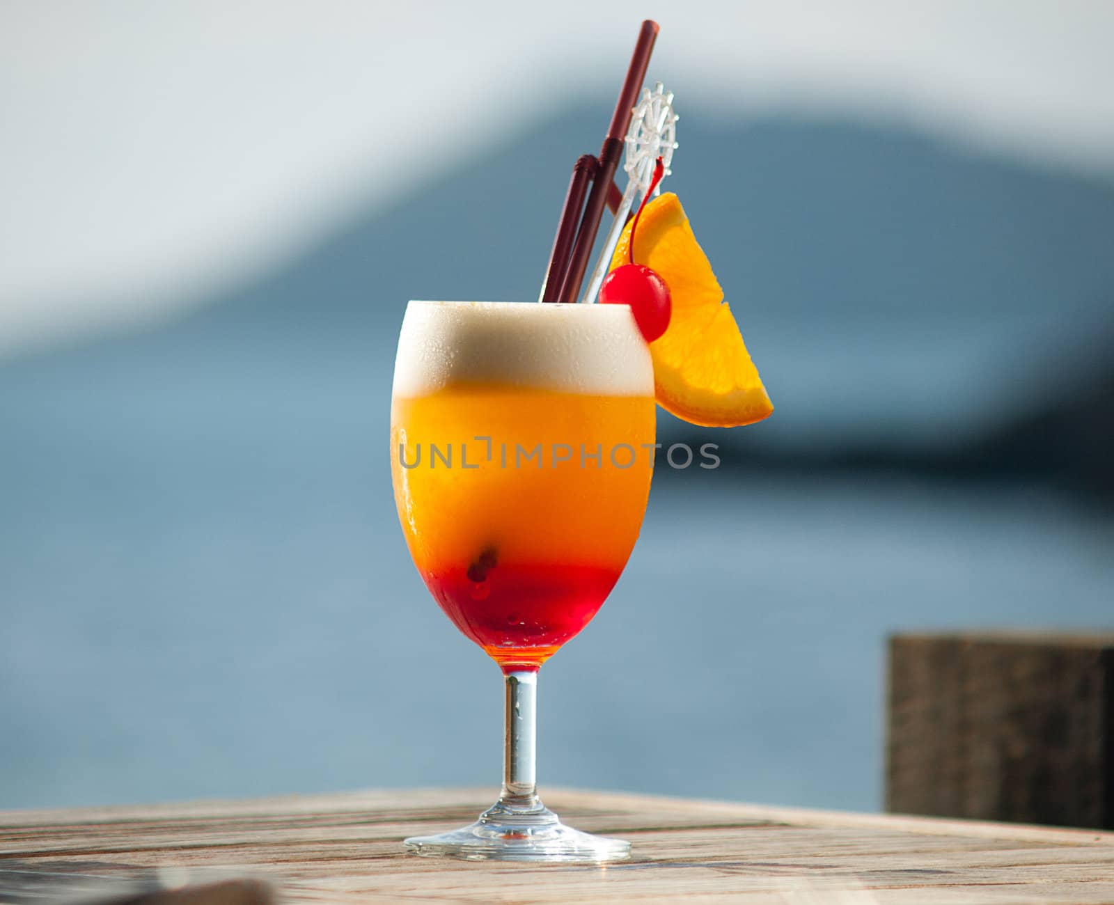 Juicy cocktail on wooden table by the sea can make you refresh in hot day