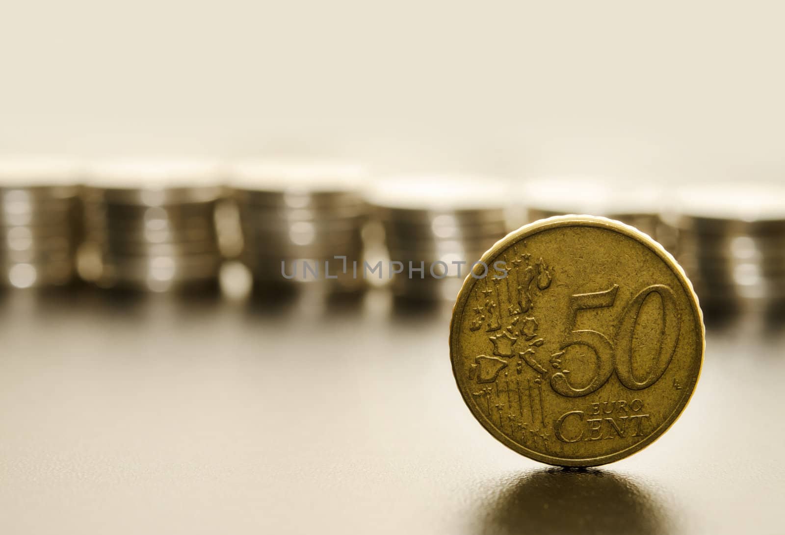 Macro shoot of a euro coin with stacks of coins in the background
