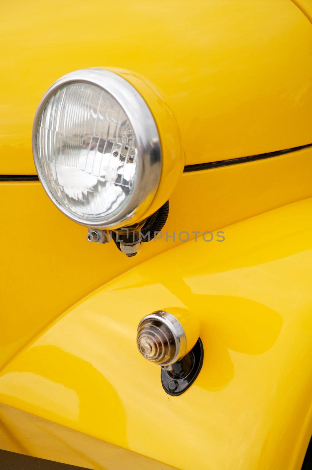 Headlight and small headlamp on yellow close up