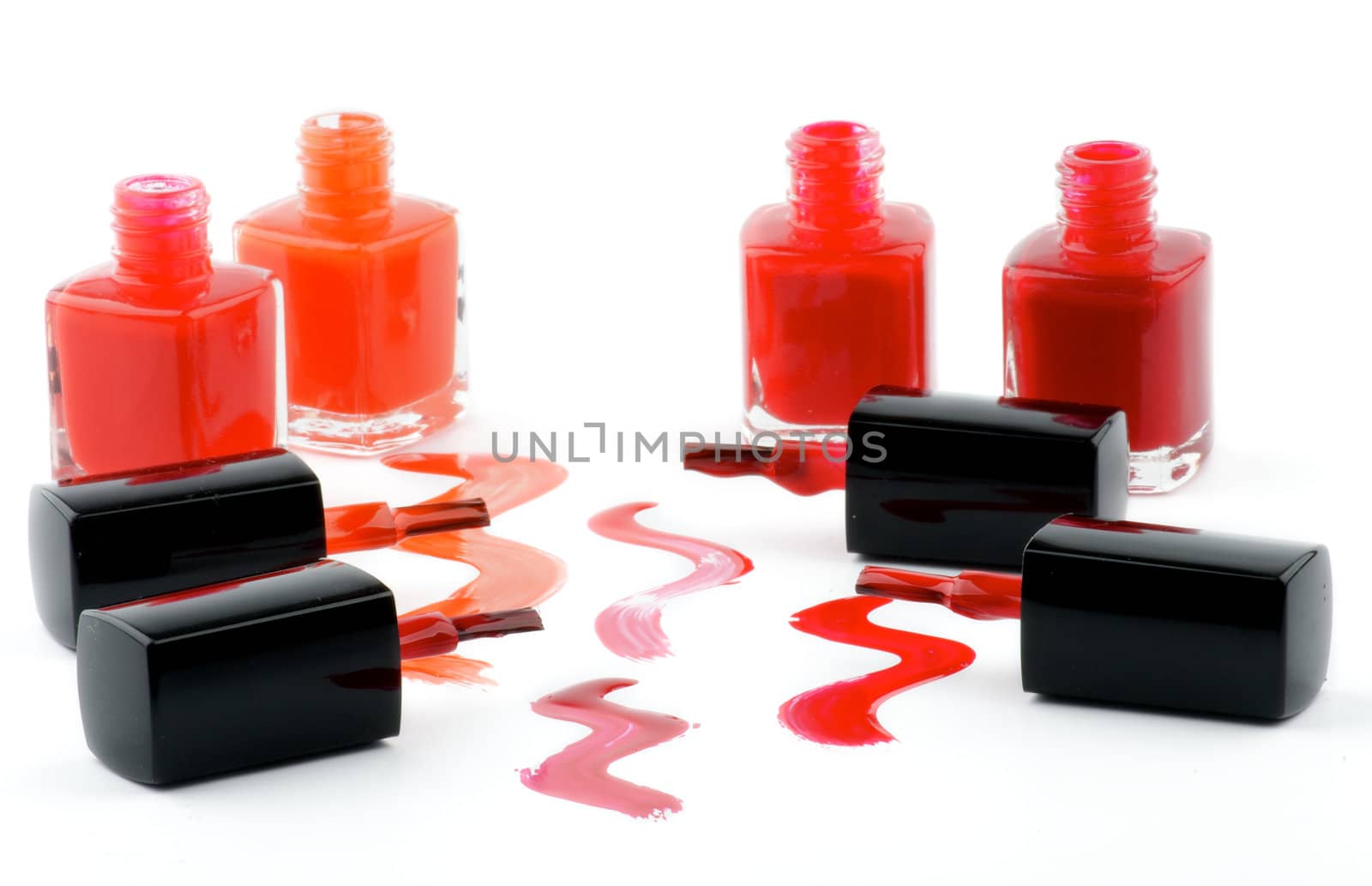 Four Bright Nail Varnishs and Spilled with Brushes isolated on white background