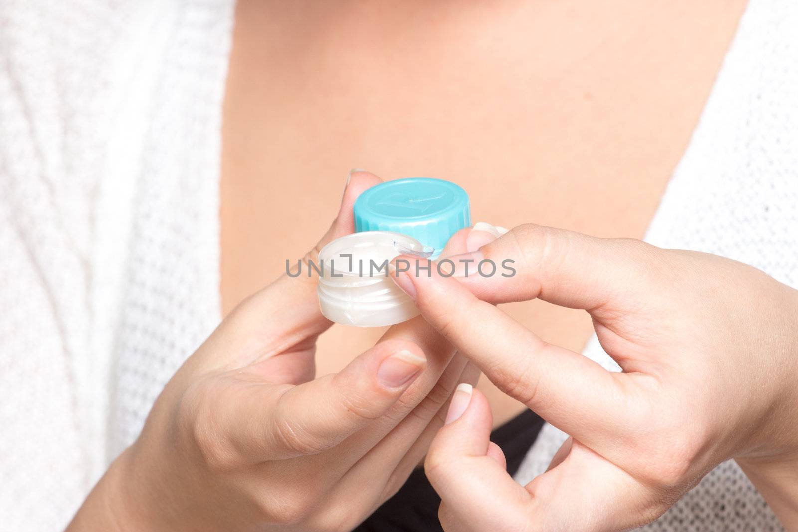 Contact lenses box in womans hand, isolated on white