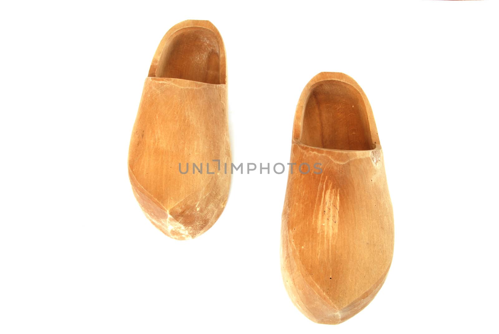 A pair of ancient wooden shoes on white 