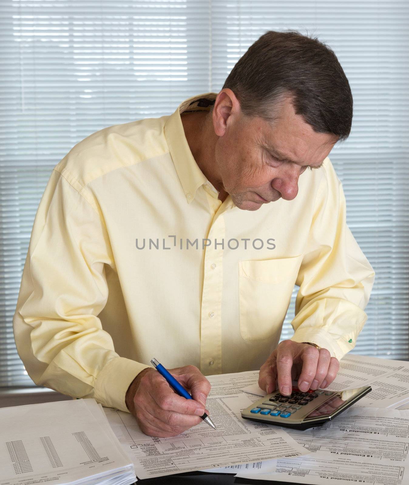 Senior man preparing USA tax form 1040 for 2012 by steheap
