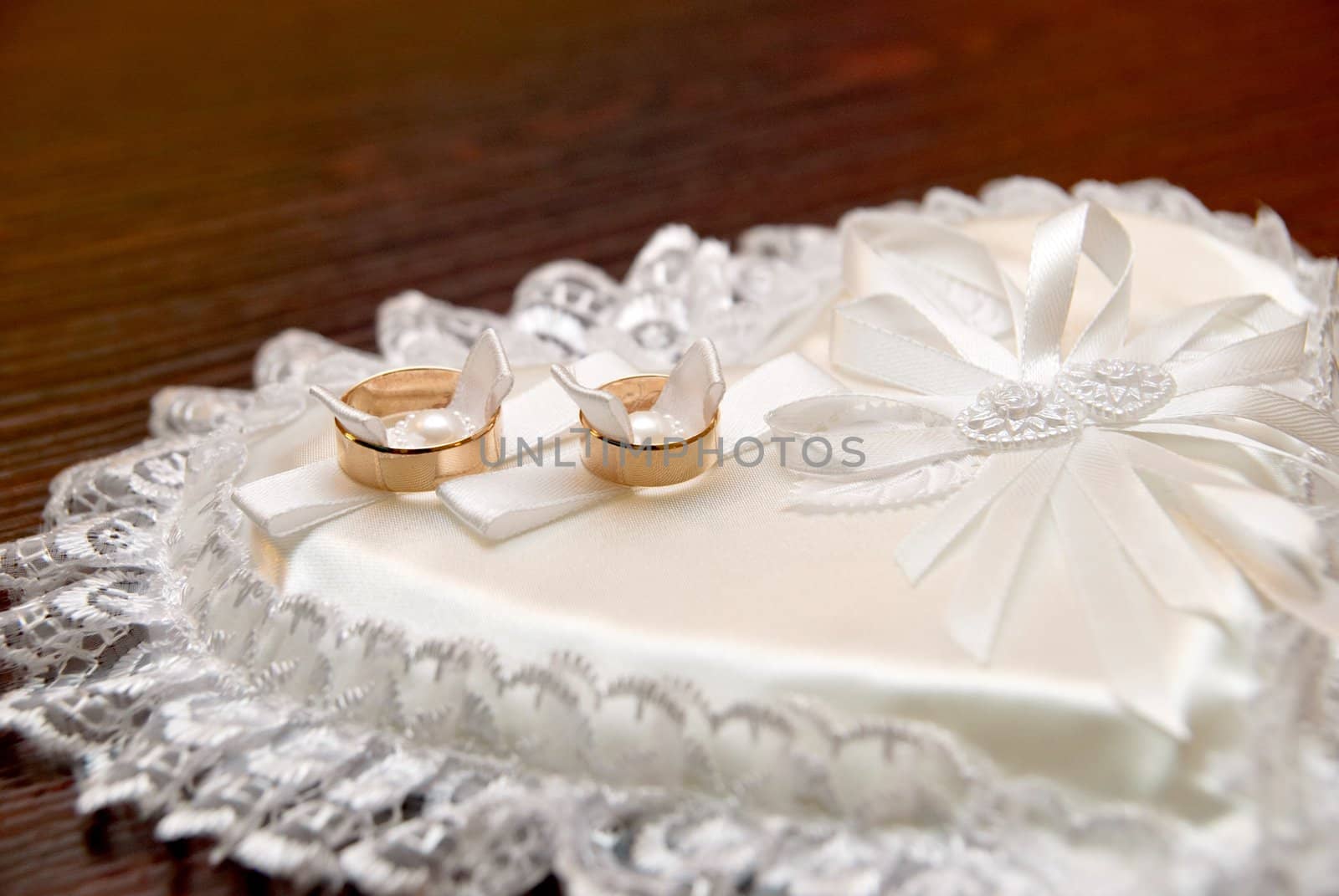 Two wedding rings on a heart-shaped pad
