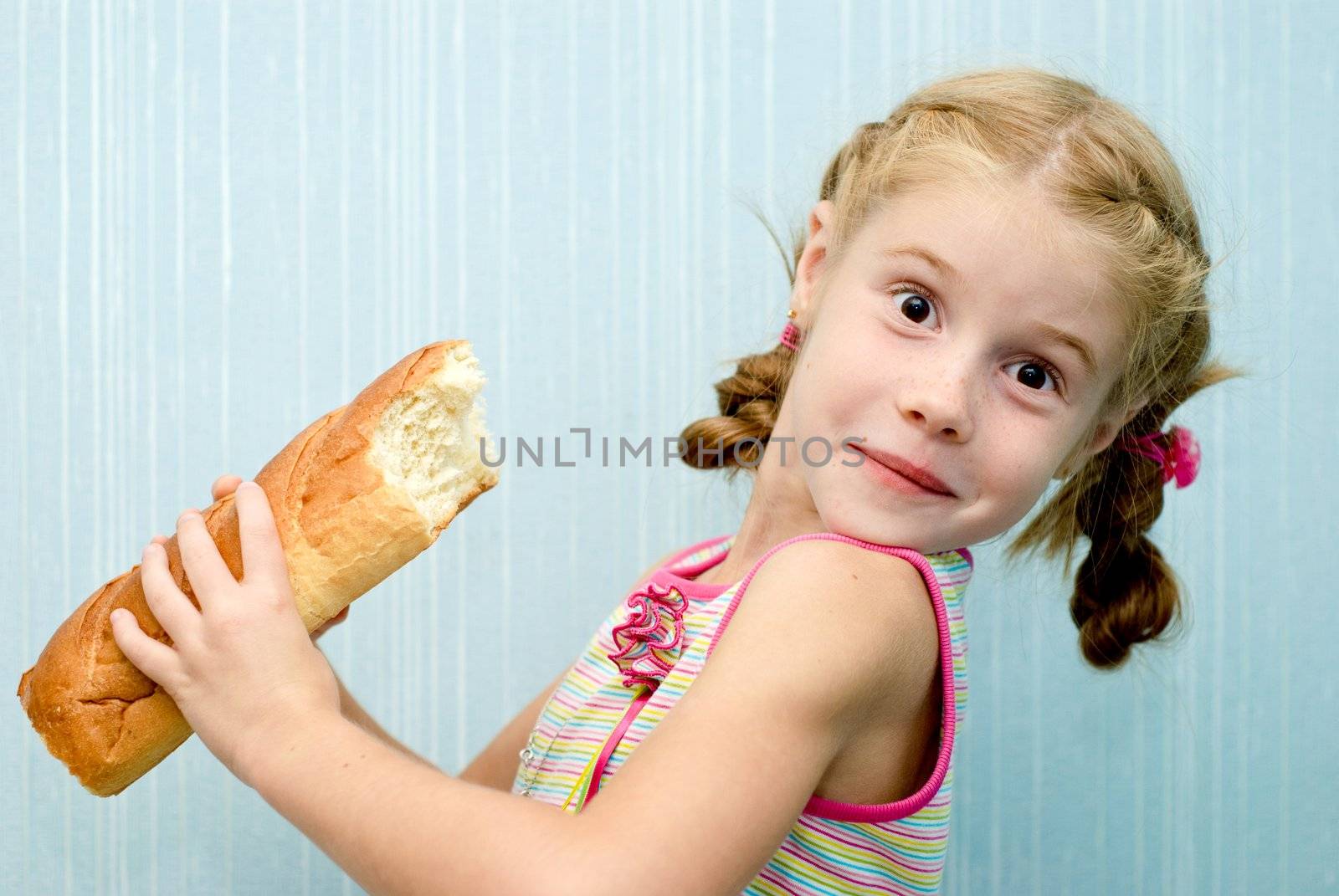 Portrait of a little girl with a loaf of bread