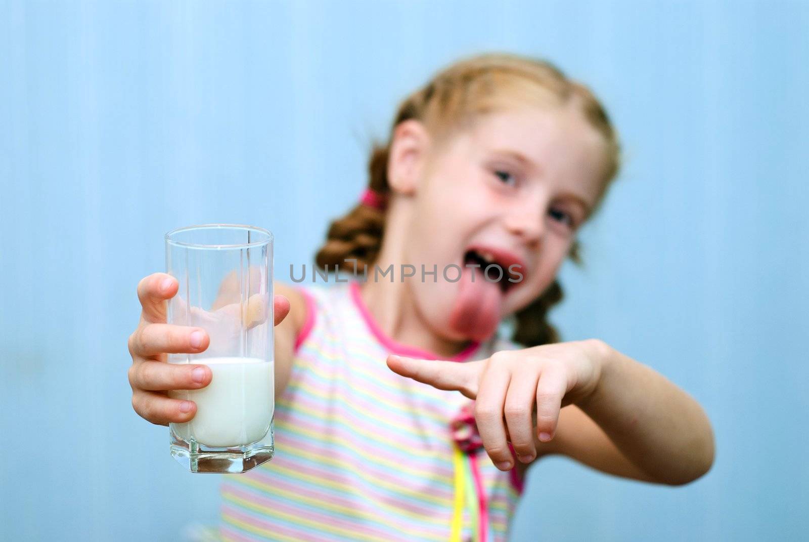 Portrait of a little toothless girl a glass of milk