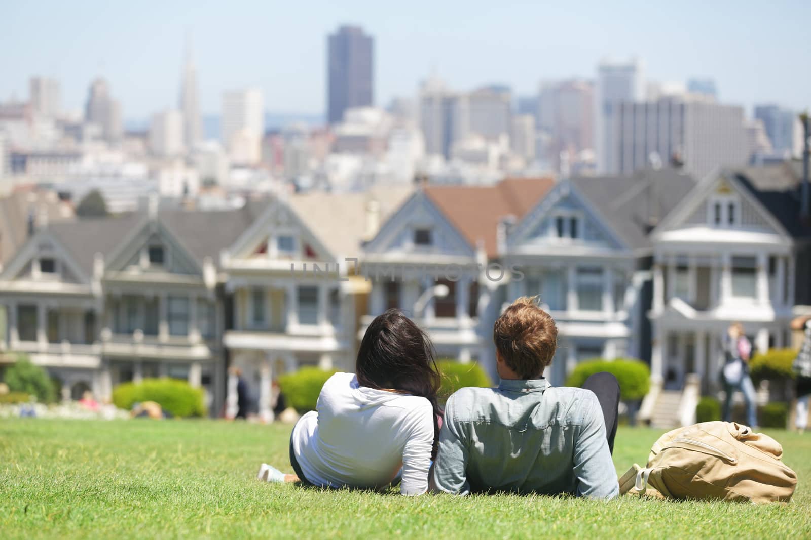 San Francisco - Alamo Square people. Couple in Alamo Park by the Painted Ladies, The Seven Sisters, San Francisco, California, USA.