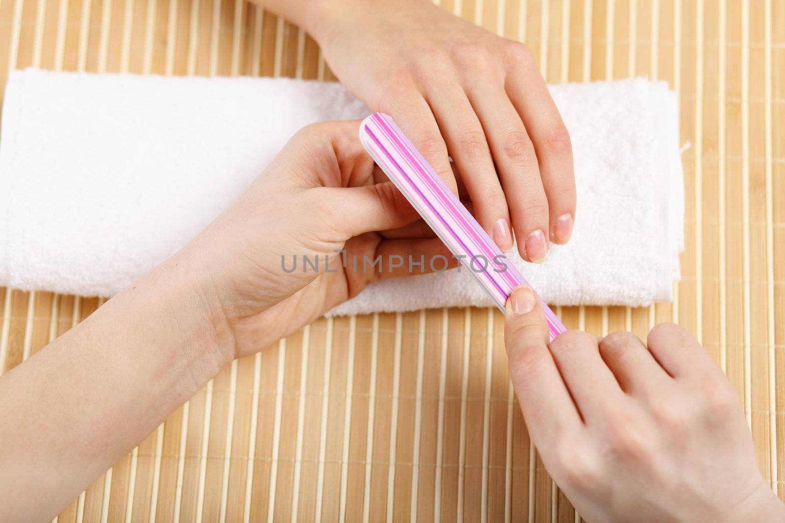 Young woman is getting manicure in a beauty salon