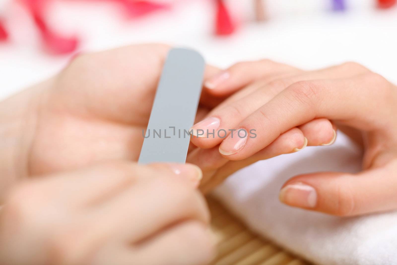 Young woman is getting manicure in a beauty salon