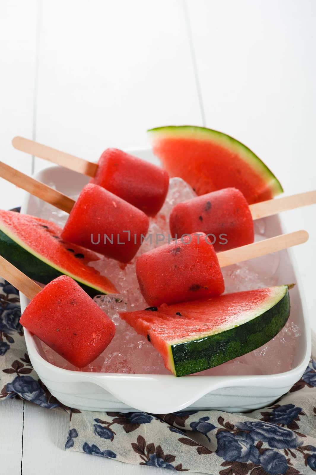 watermelon popsicle in a white bowl with ice and fresch watermelon