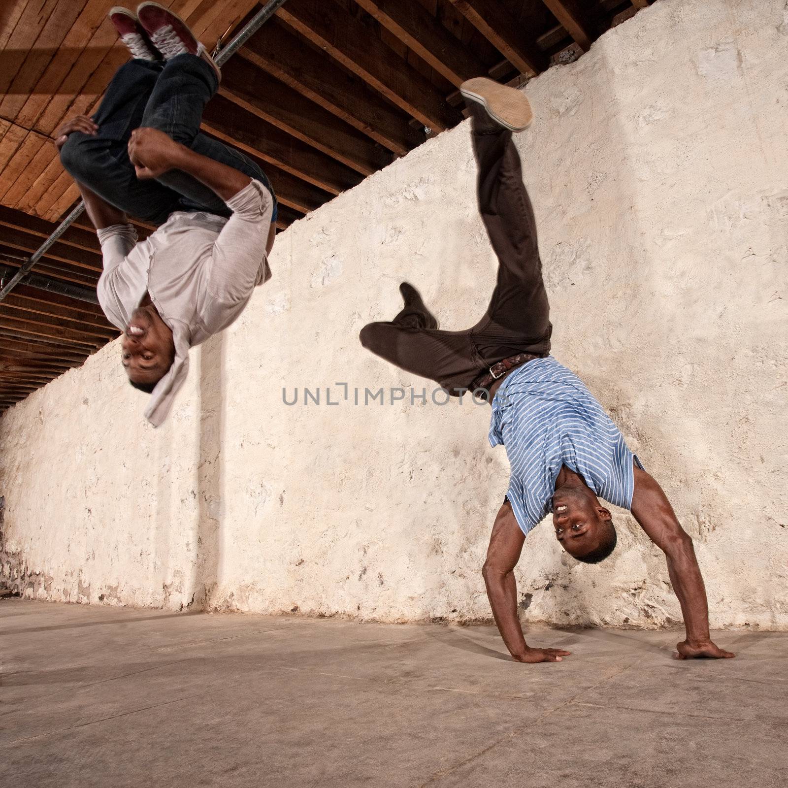 Agile capoeria martial artists perform acrobatic techniques