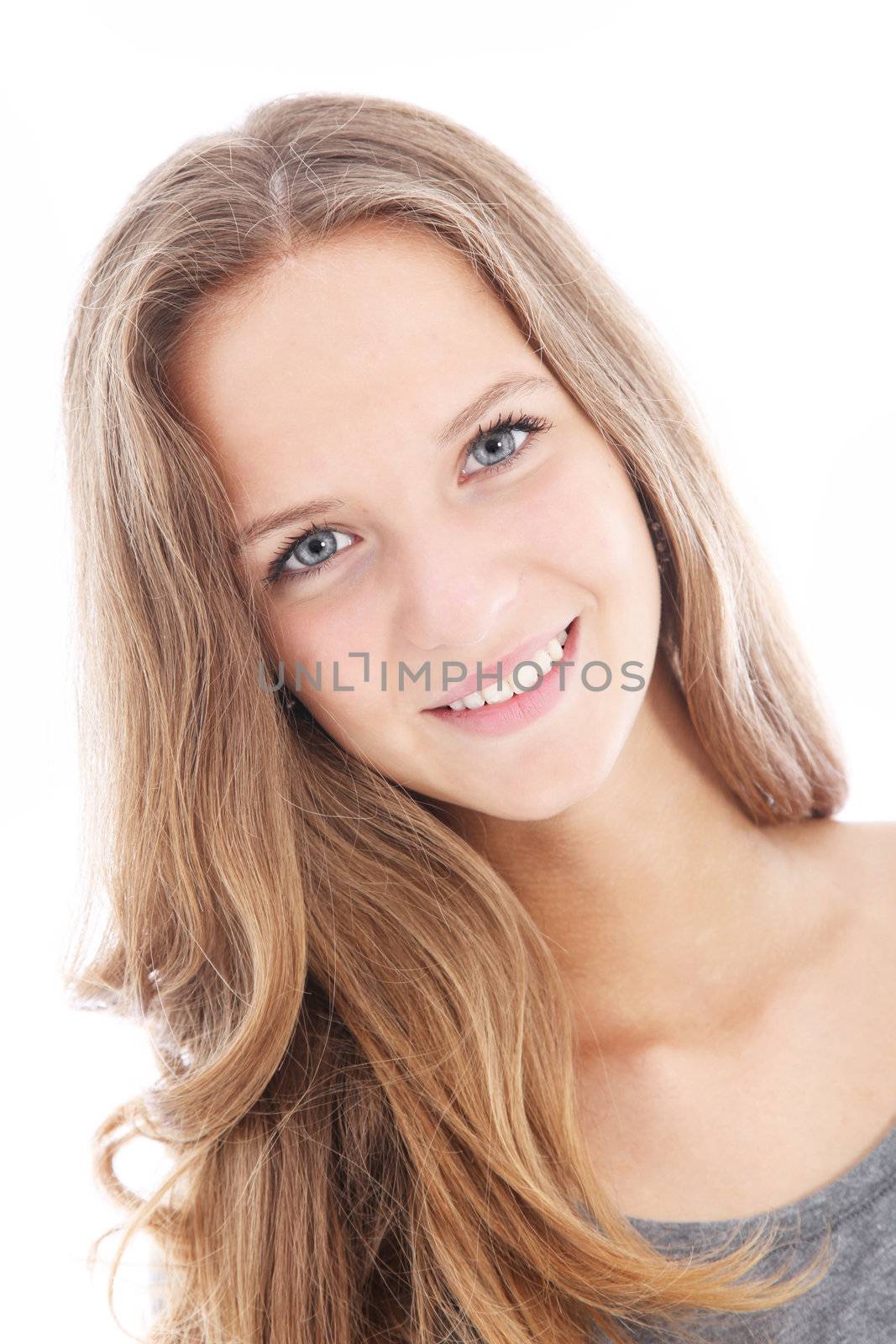 Pretty friendly teenager with her head slightly tilted smiling happily at the camera isolated on white 