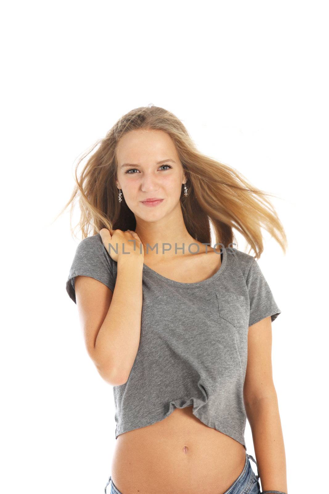 Windblown young woman in casual jeans and top standing with the breeze blowing through her long blonde hair isolated on white Windblown young woman in casual jeans and top standing with the breeze blowing through her long blande hair isolated on white 