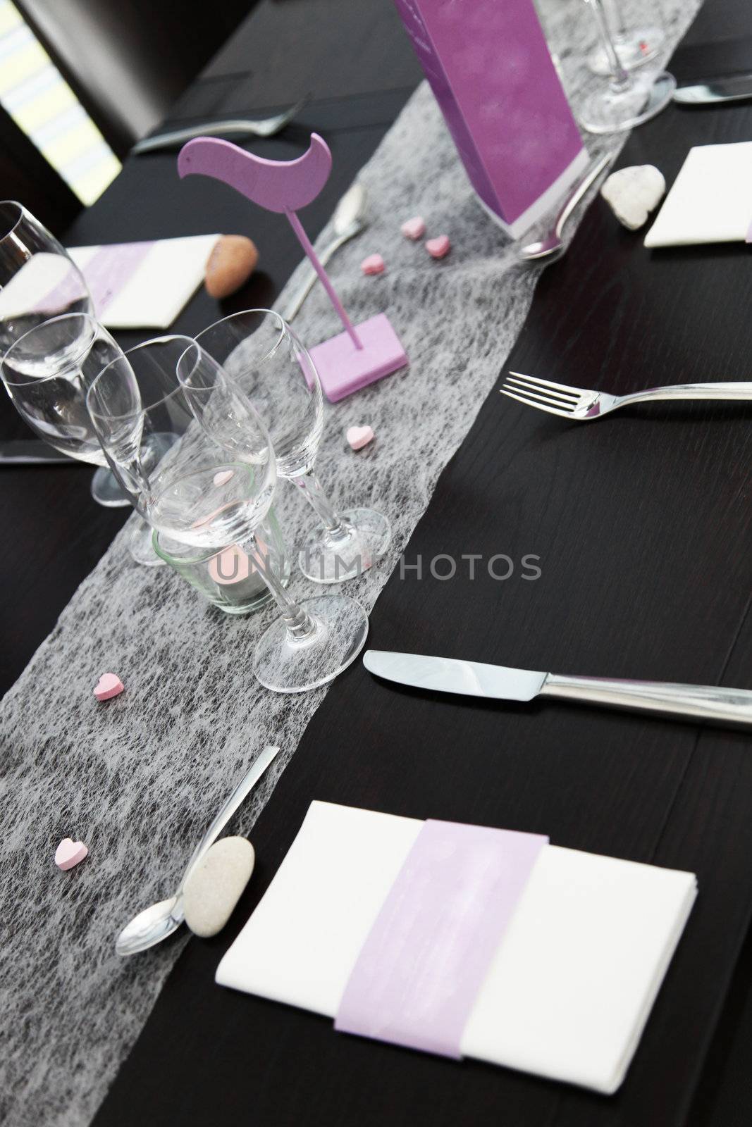 Elegant formal table setting with silverware, linen and glasses on a black tablecoth at a restaurant or catered event Elegant formal table setting with sliberware, linen and glasses on a black tablecoth at a restaurant or catered event 