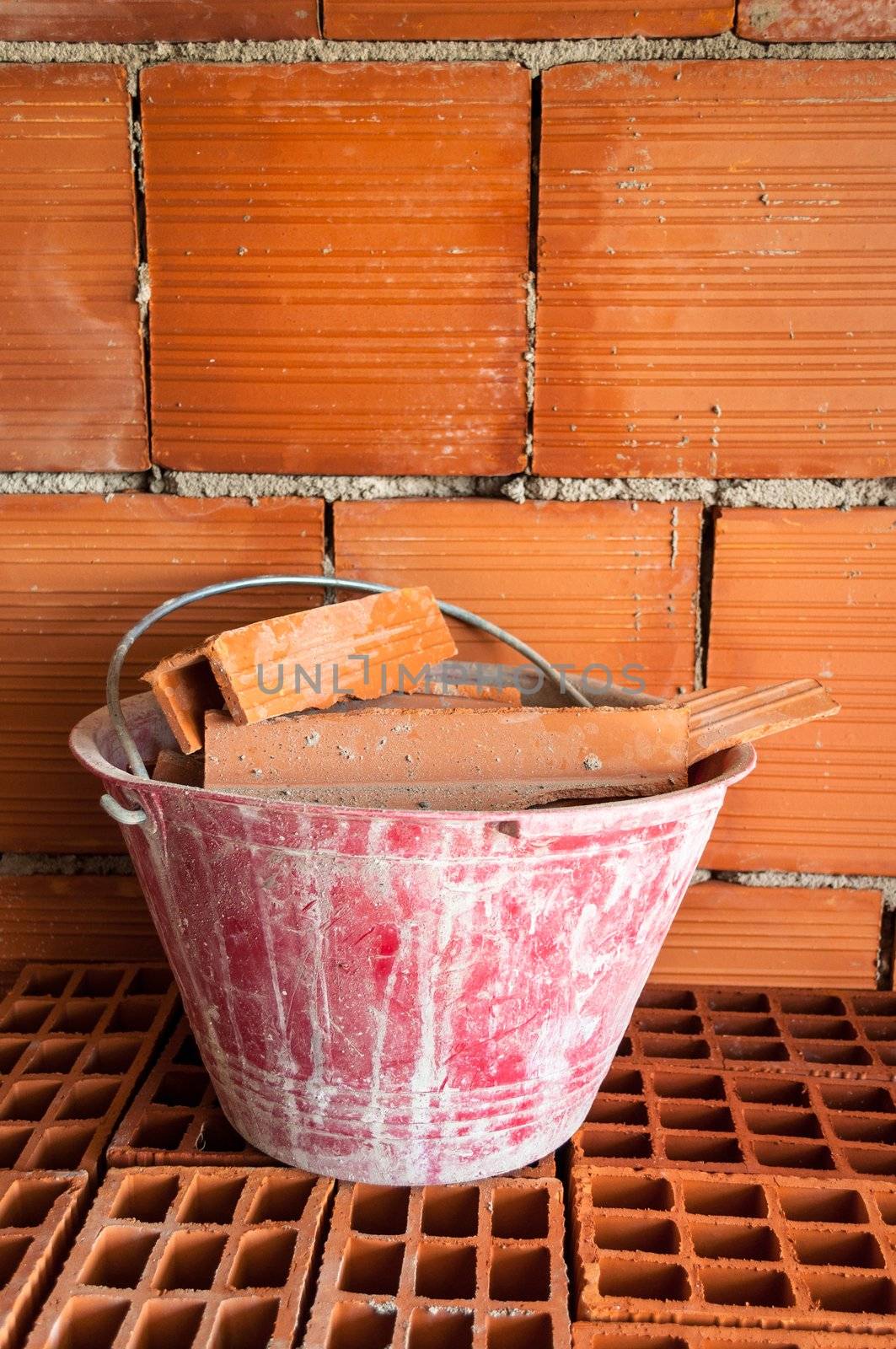 Masonry Red bucket on hollow bricks with in a work site.