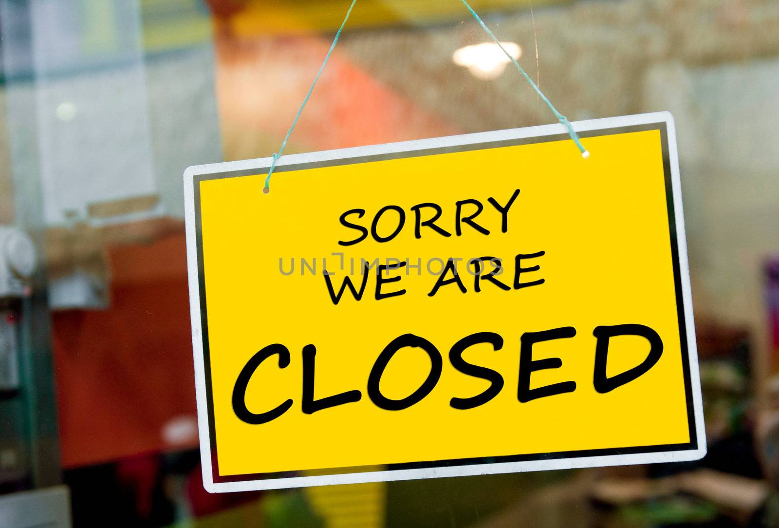 sorry we are closed sign hanging on a window door outside a restaurant, store, office or other