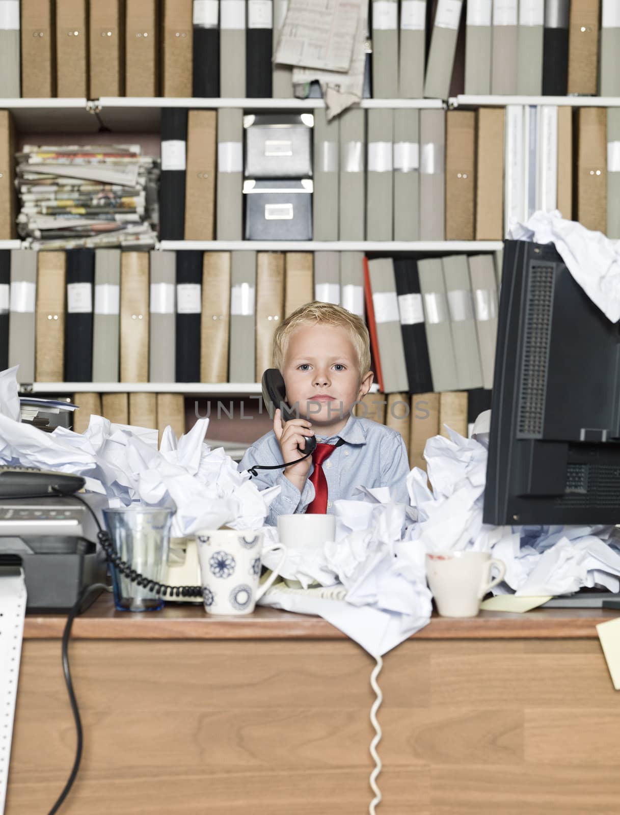 Young business man on the phone in a messy office