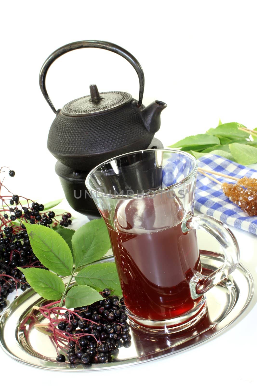 a glass of elderberry tea with fresh elderberries