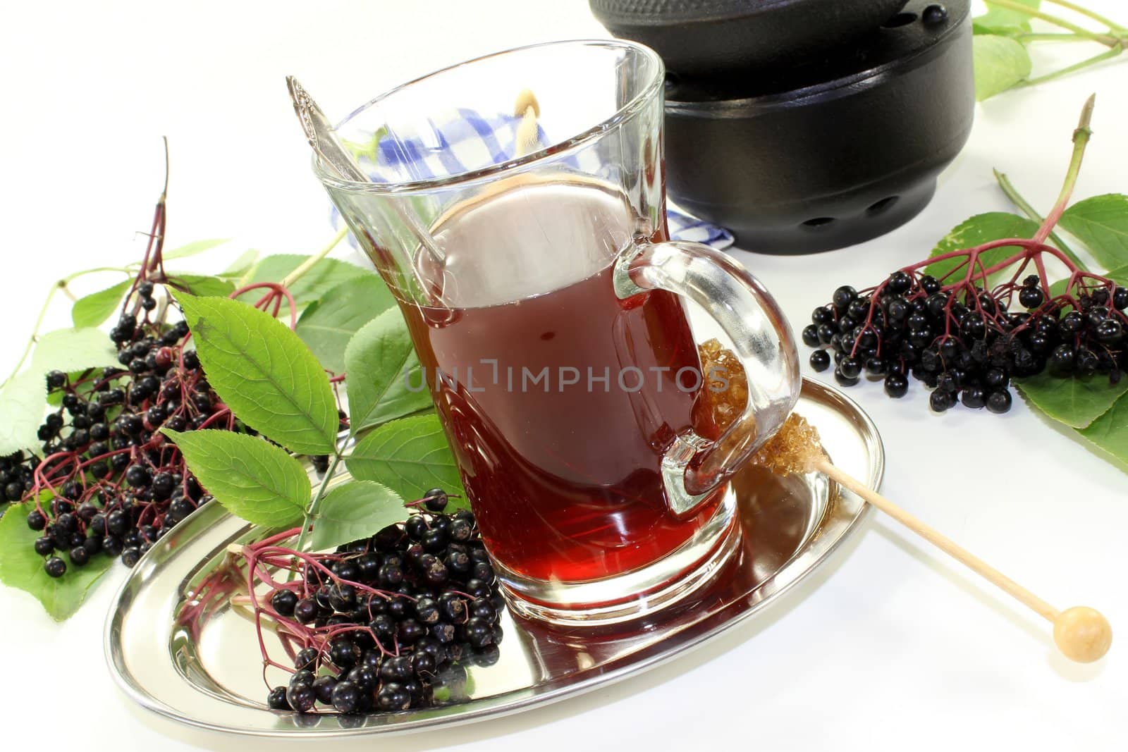 a glass of elderberry tea with fresh elderberries