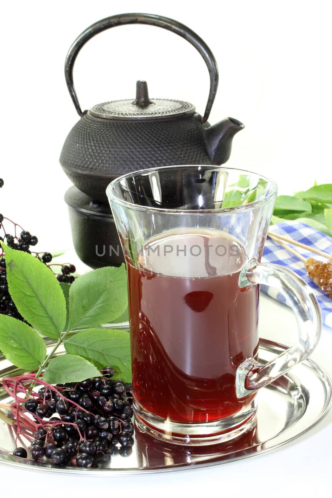 a glass of elderberry tea with fresh elderberries