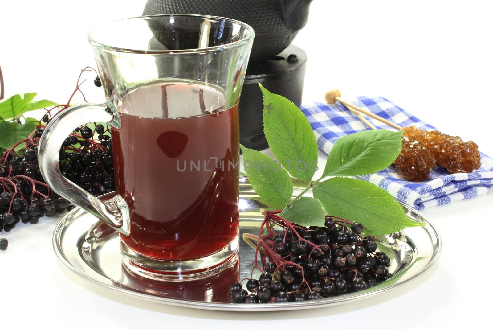 a glass of elderberry tea with fresh elderberries