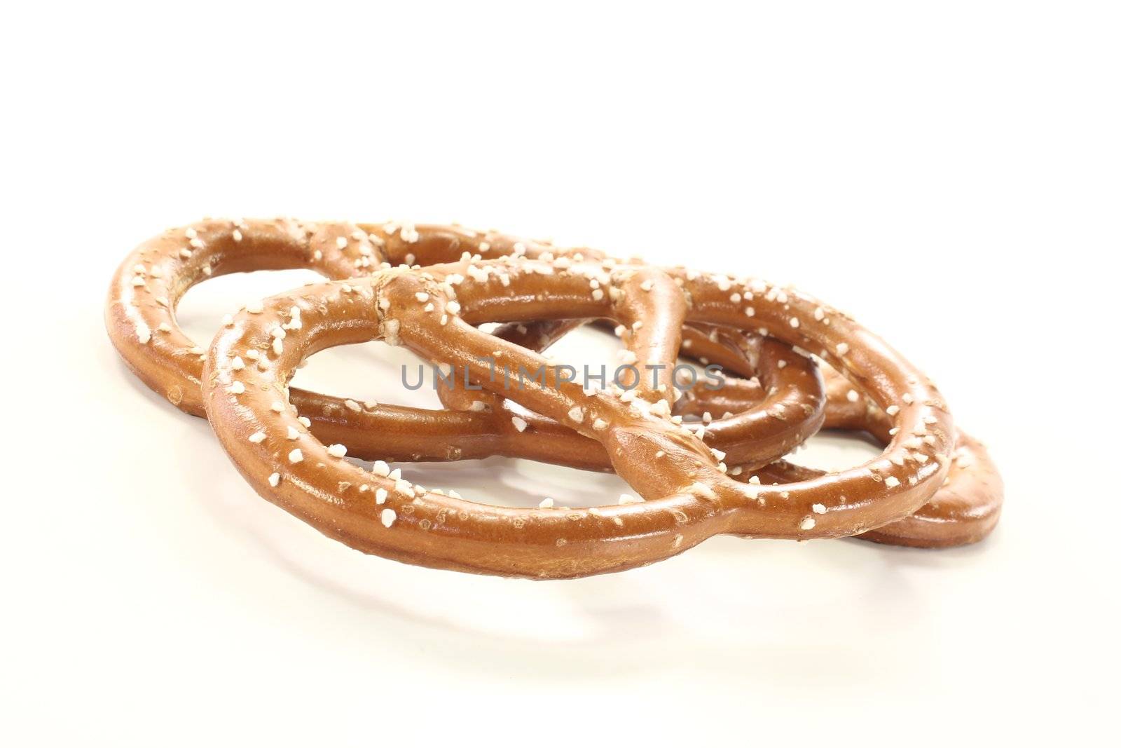 three Bavarian pretzels with salt on a bright background