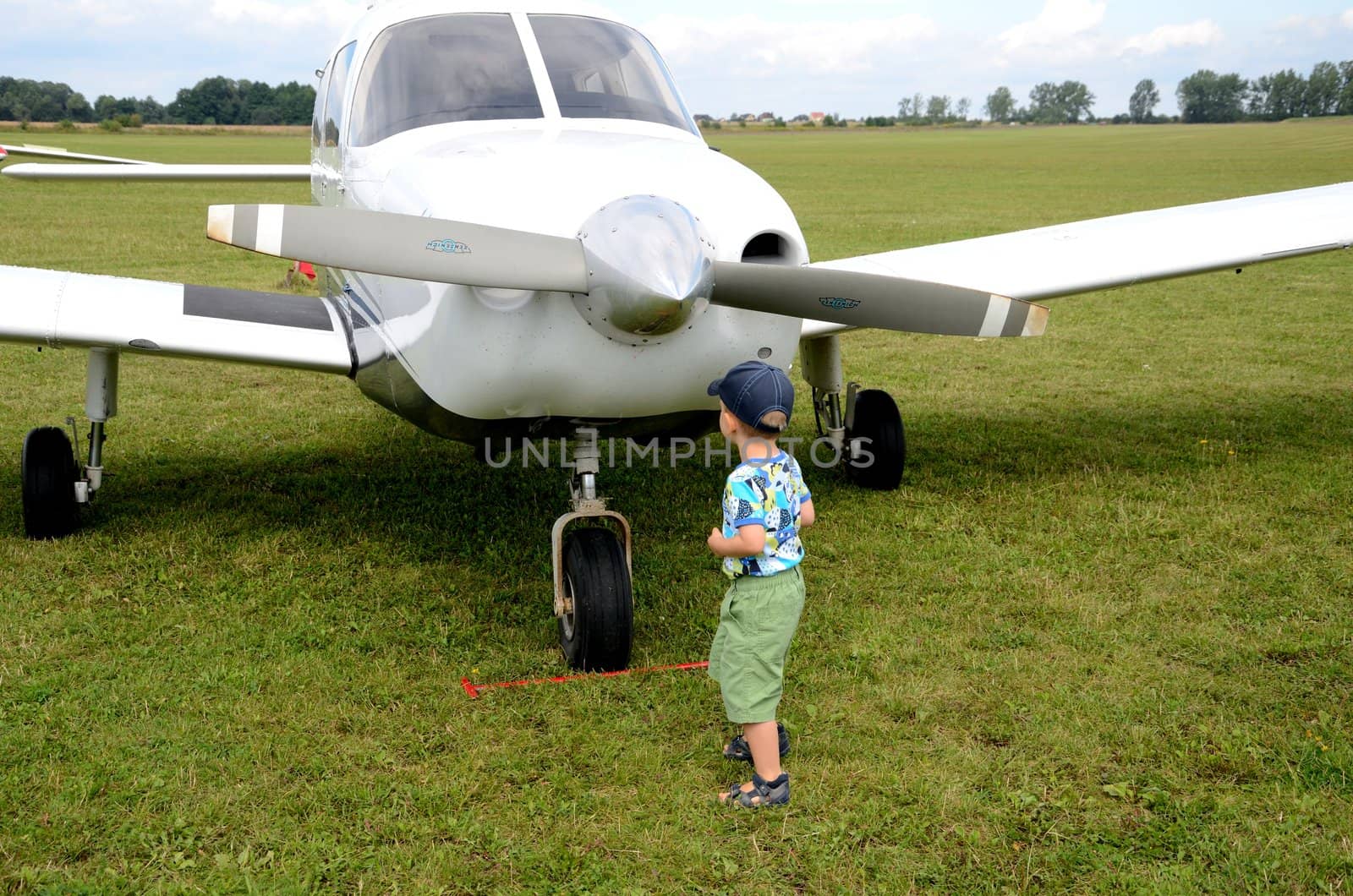 SZYMANOW, POLAND - AUGUST 25: Unidentified small boy approches Cessna plane during air show on August 25, 2012 in Szymanow.