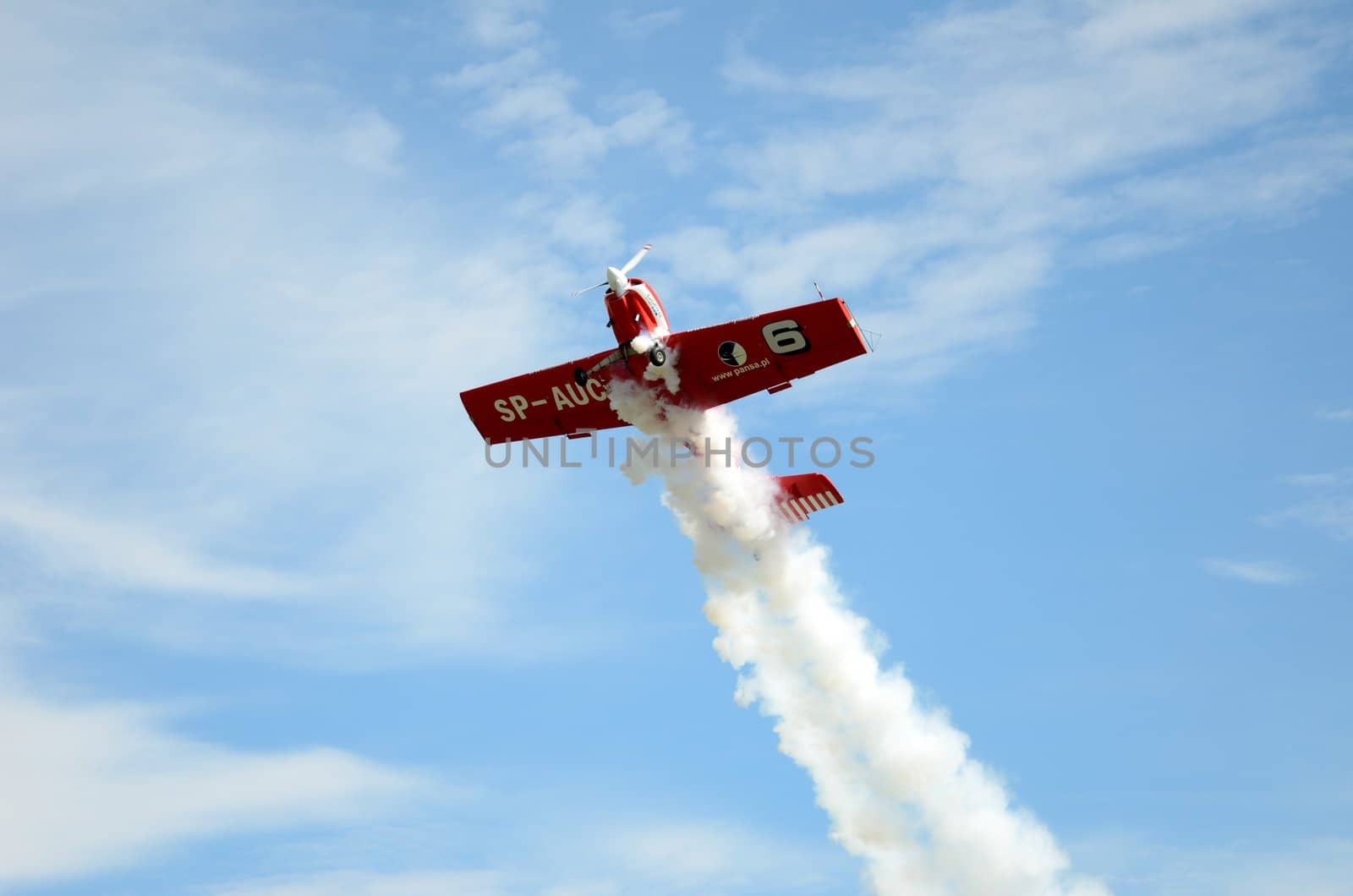 SZYMANOW, POLAND - AUGUST 25: Pilot Tadeusz Kolaszewski performs acrobatic show in plane Zlin-50 LS on August 25, 2012 in Szymanow.