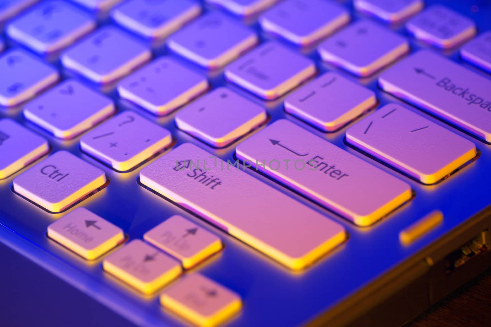 Keyboard modern laptop photographed with the effect of colored illumination