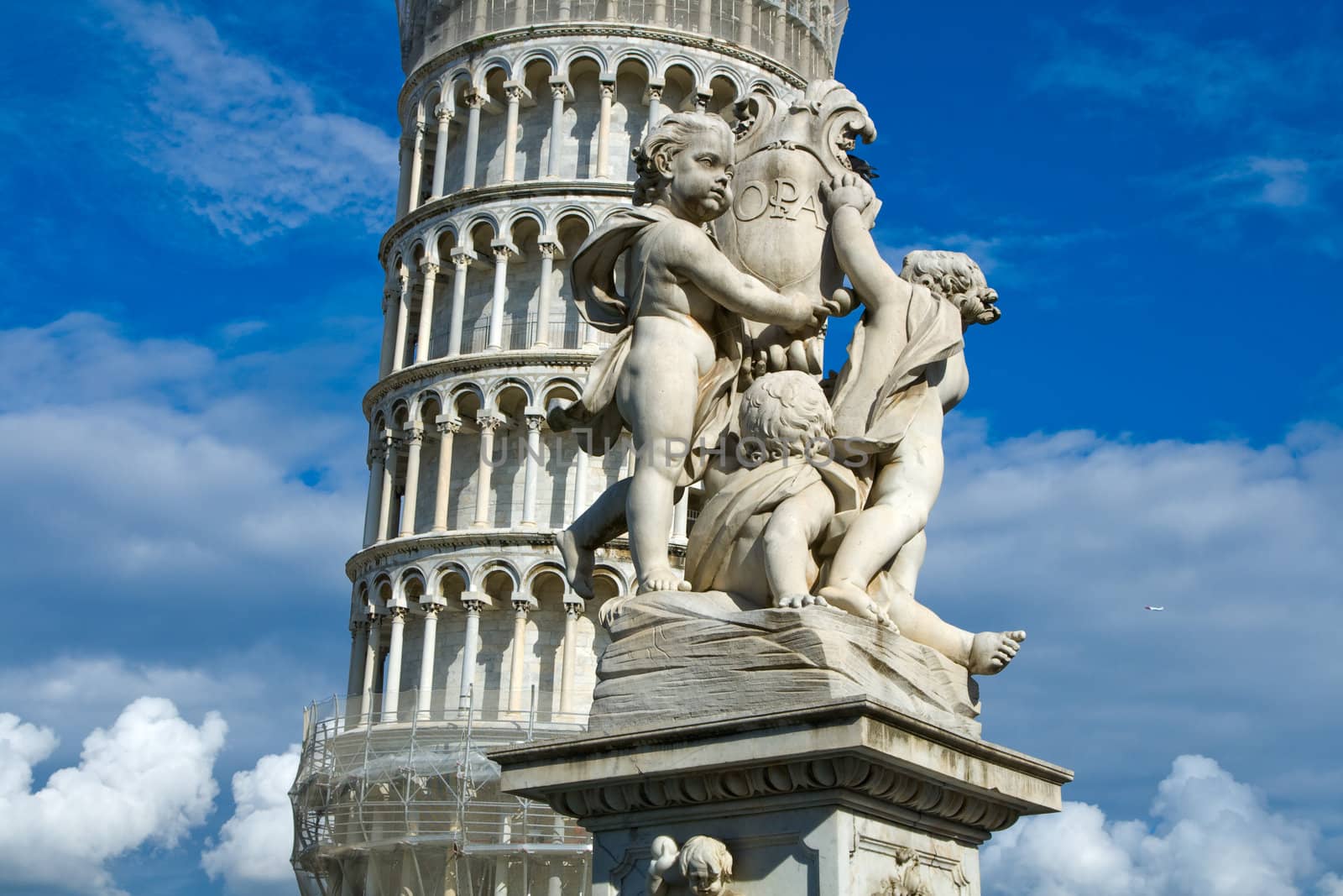 Cherub statue that sits on the Field of Miracles in Pisa Italy with the leaning tower in the background