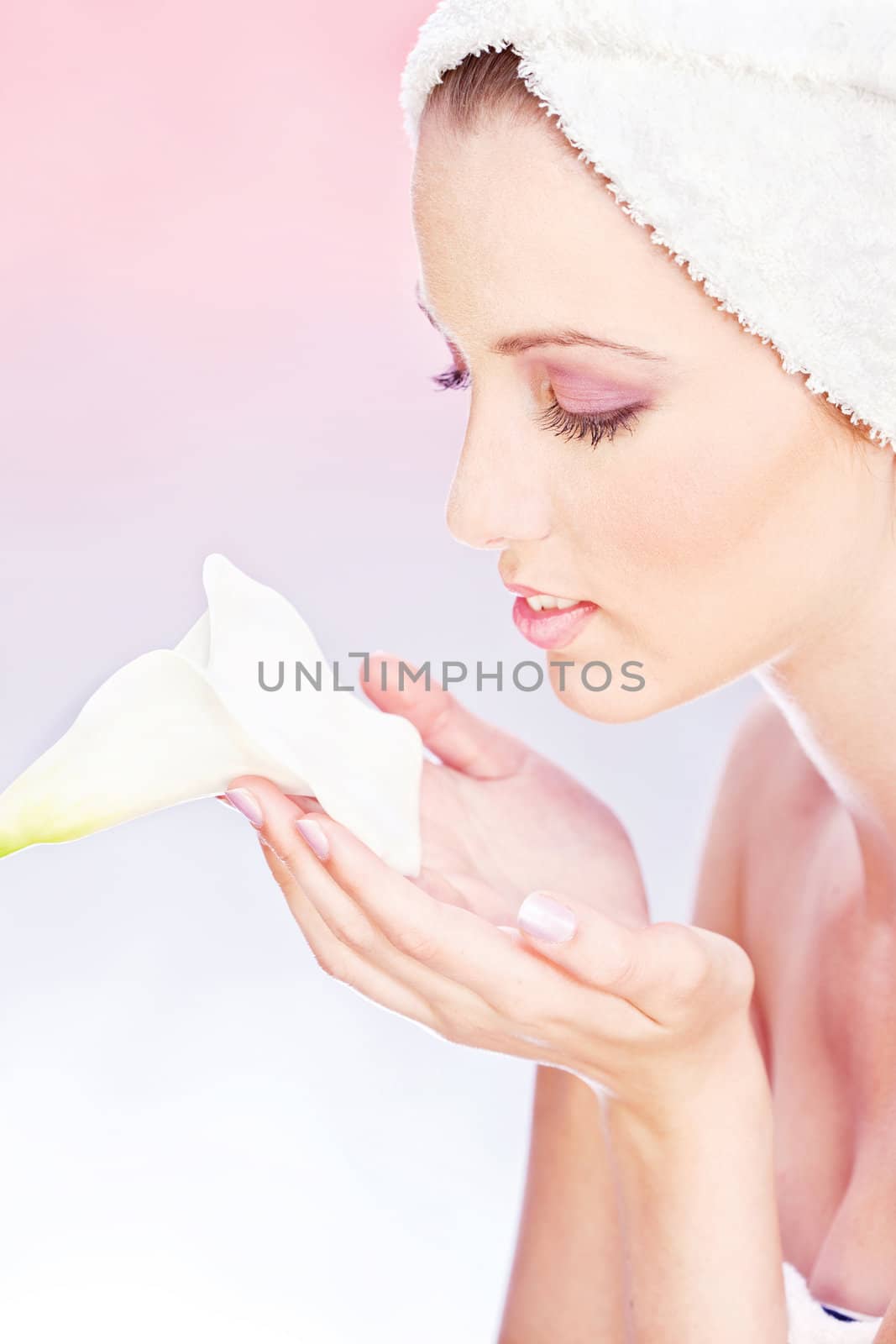 pretty woman with towel gently holding a white flower by imarin