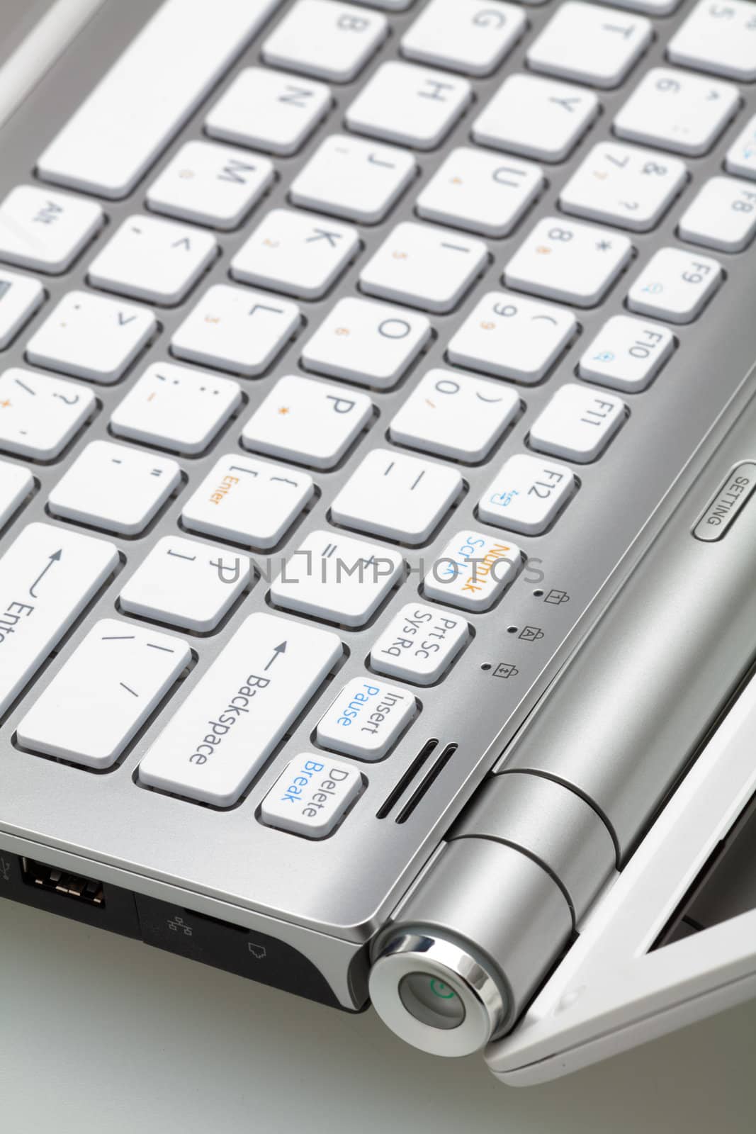 Silver laptop in the open form, a fragment of the keyboard