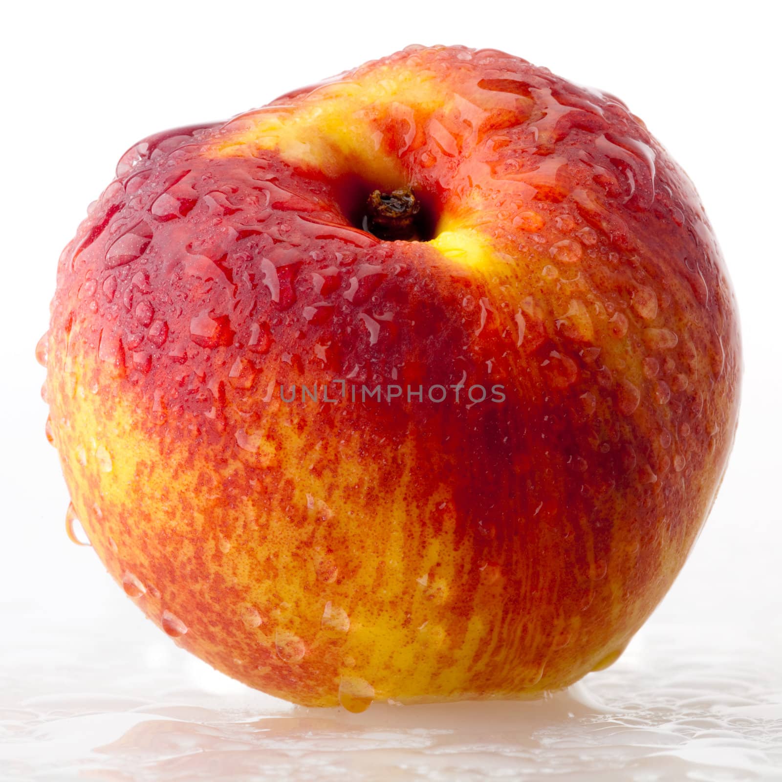 A fresh peach covered of drops on white background 