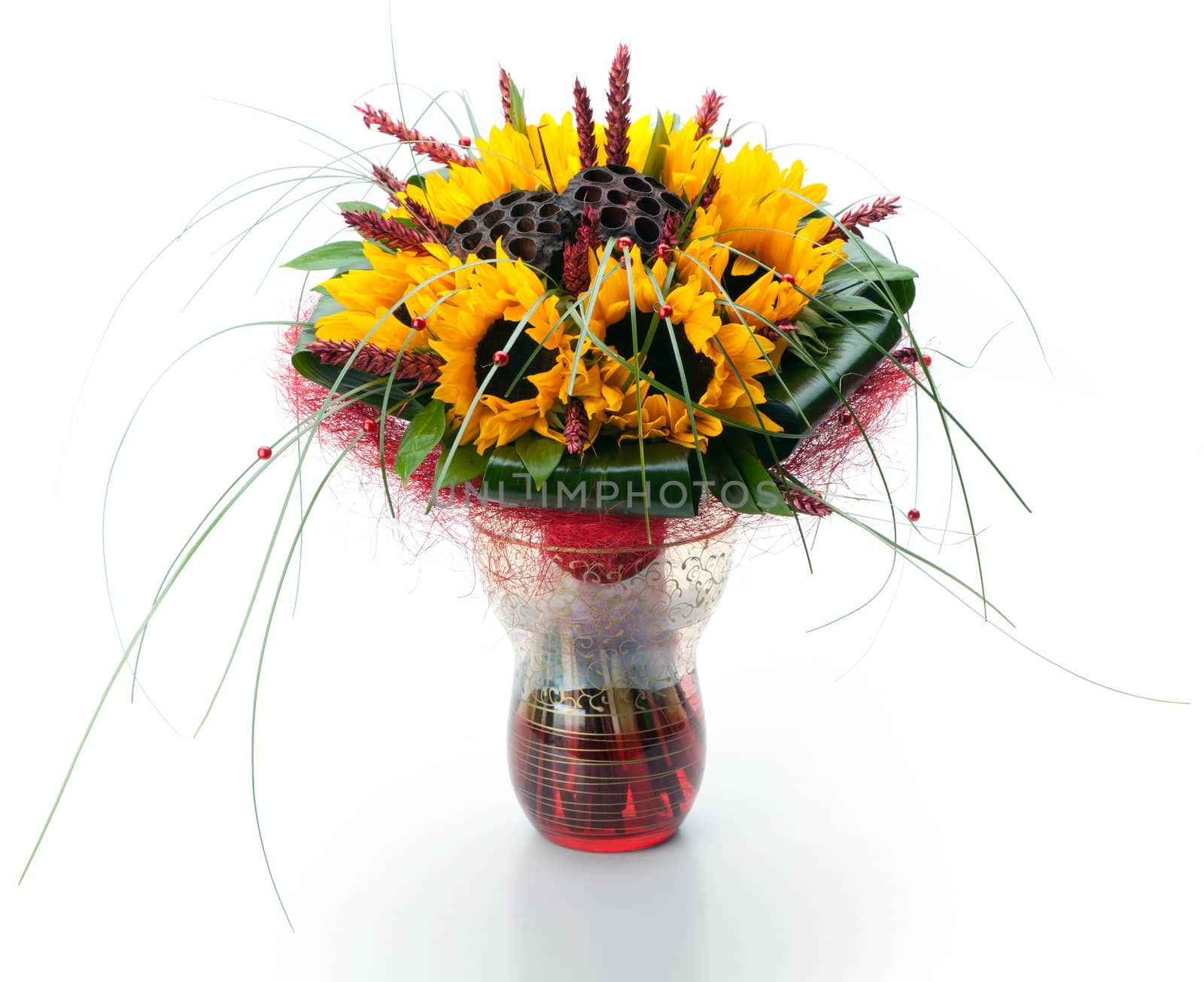 Festive composite bouquet of sunflowers and long grass in a glass vase on a white background