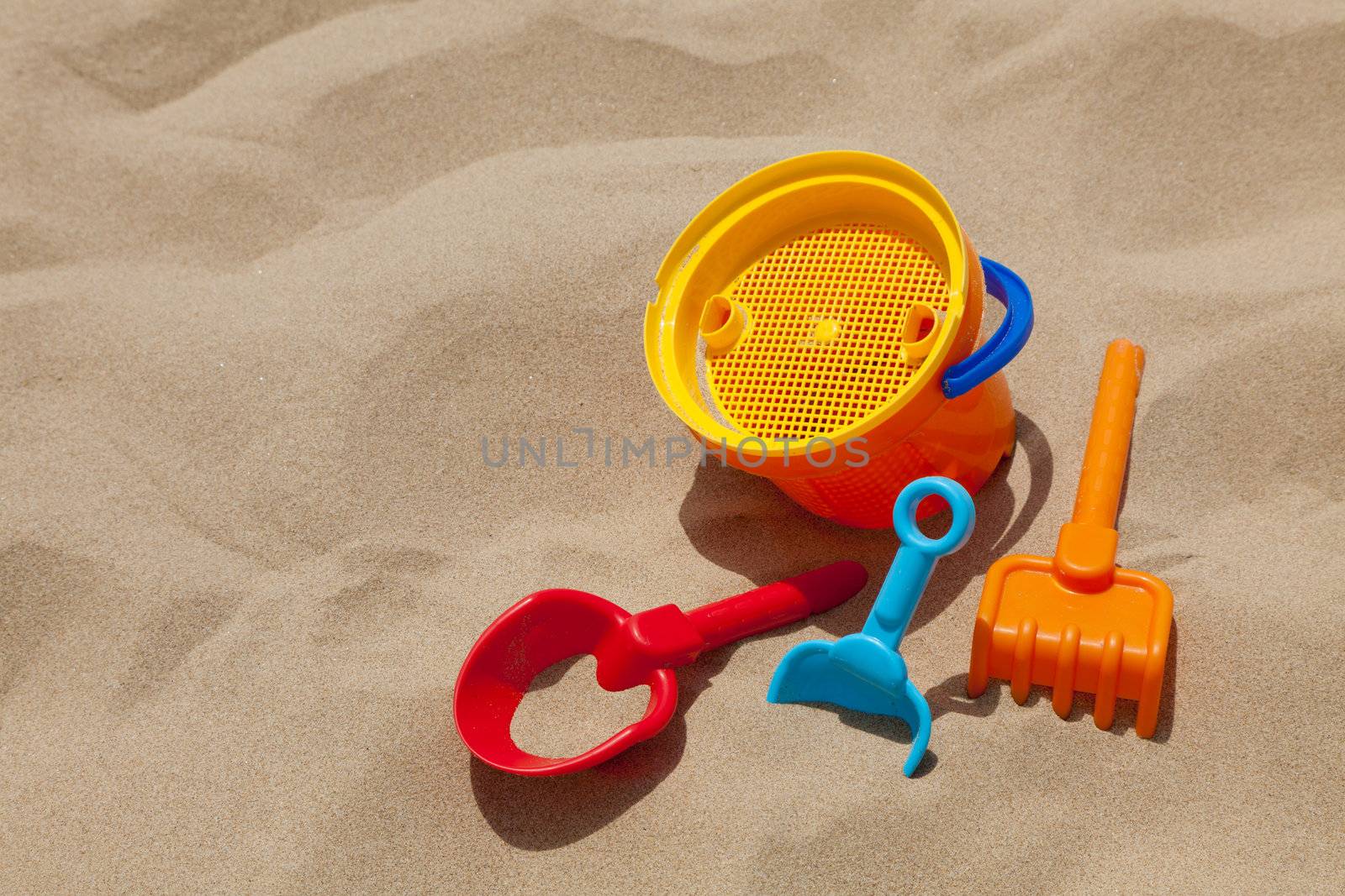 Children's beach toys - buckets, spade and shovel on sand on a sunny day