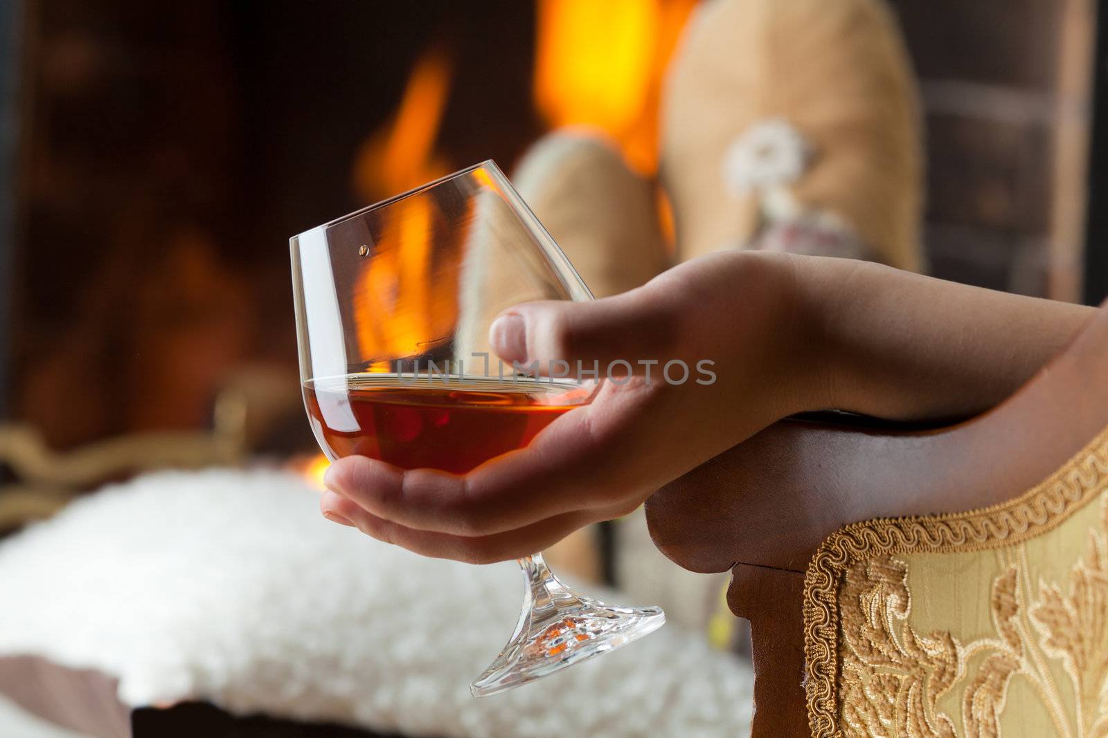 Resting at the burning fireplace fire with a glass of cognac by Antartis