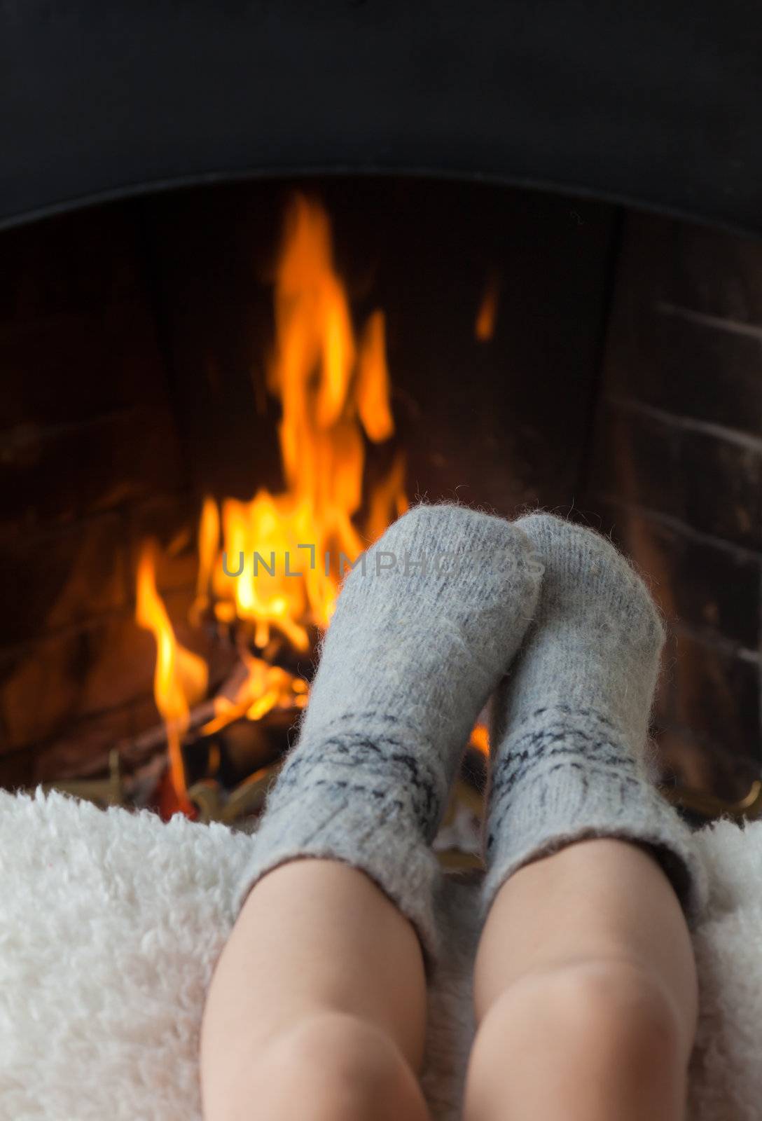 Children's feet are heated in the fireplace by Antartis