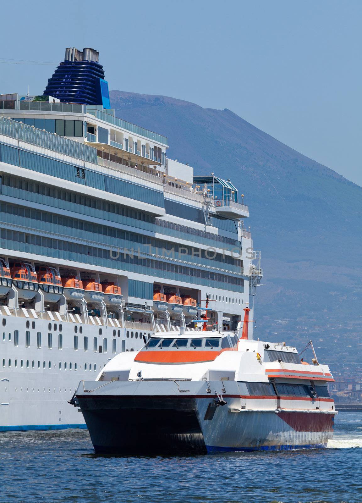 Passenger catamaran and a large cruise ship in the port of Naples