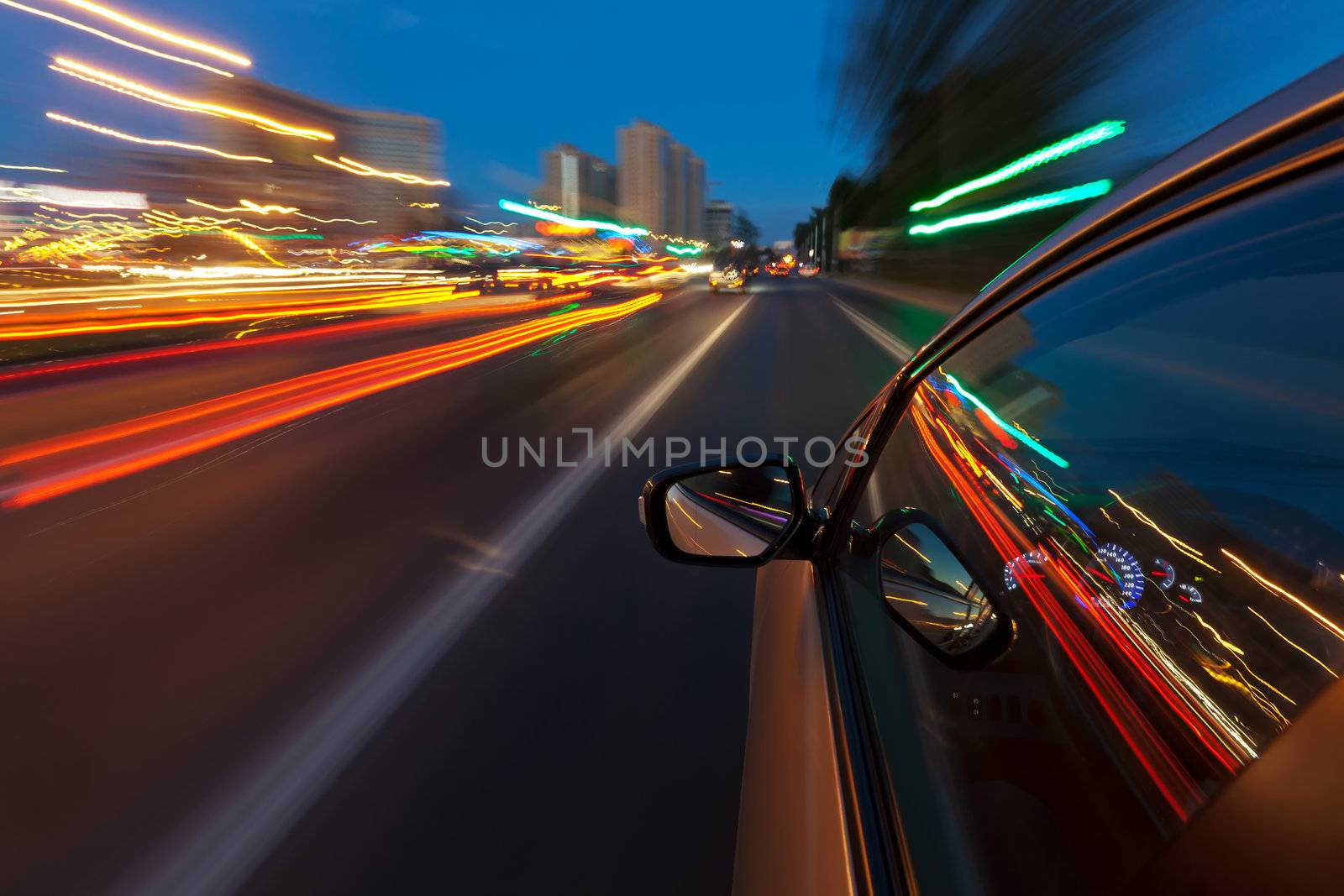 Cars driving through the city with such speed that the lights of the city reserves the long tracks