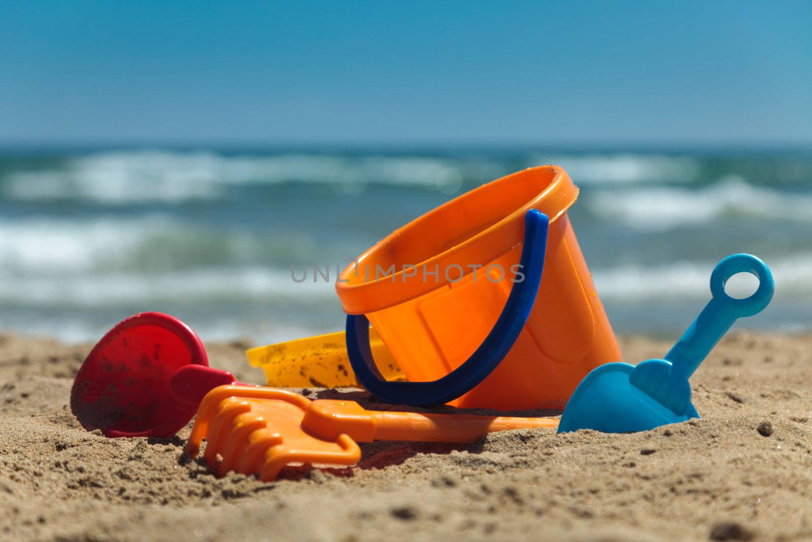 Children's beach toys - buckets, spade and shovel on sand on a sunny day