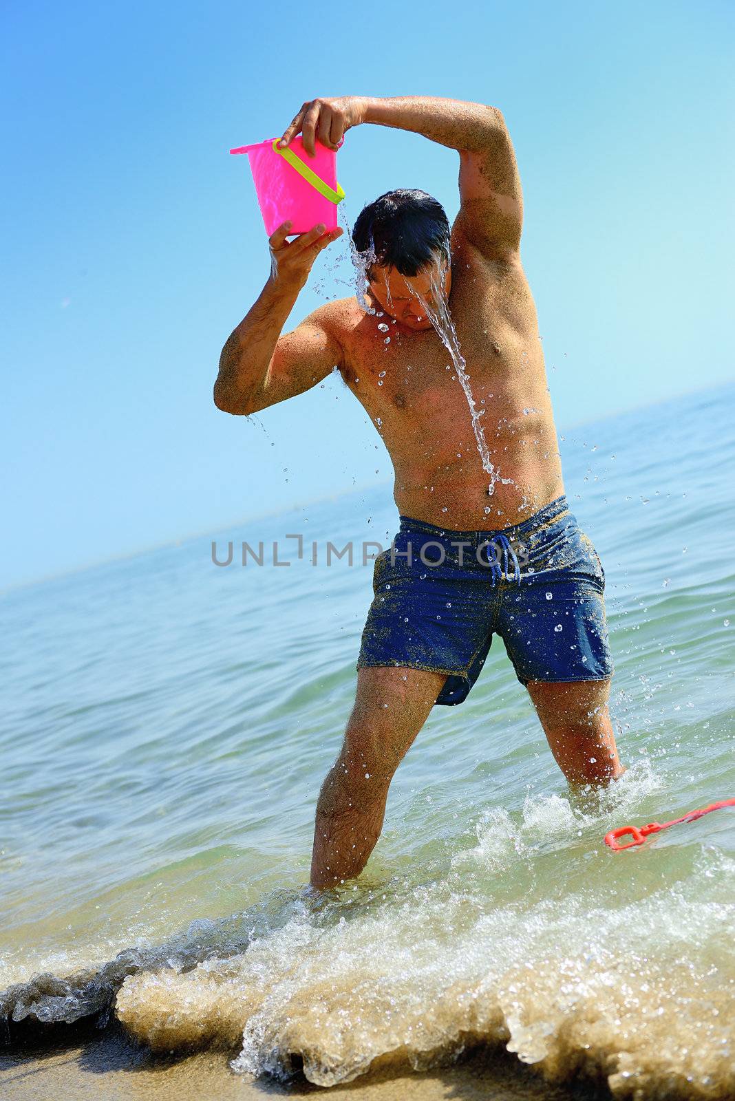 a man is having a bath on the beach in summer