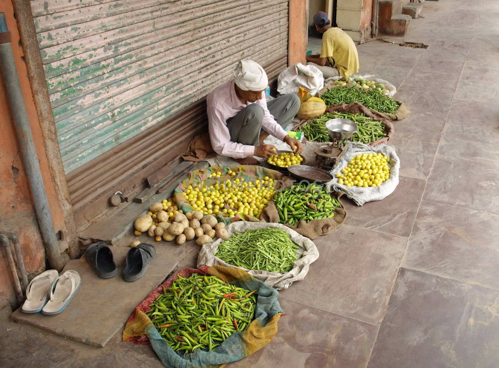 Man at indian market with colorful vegetables