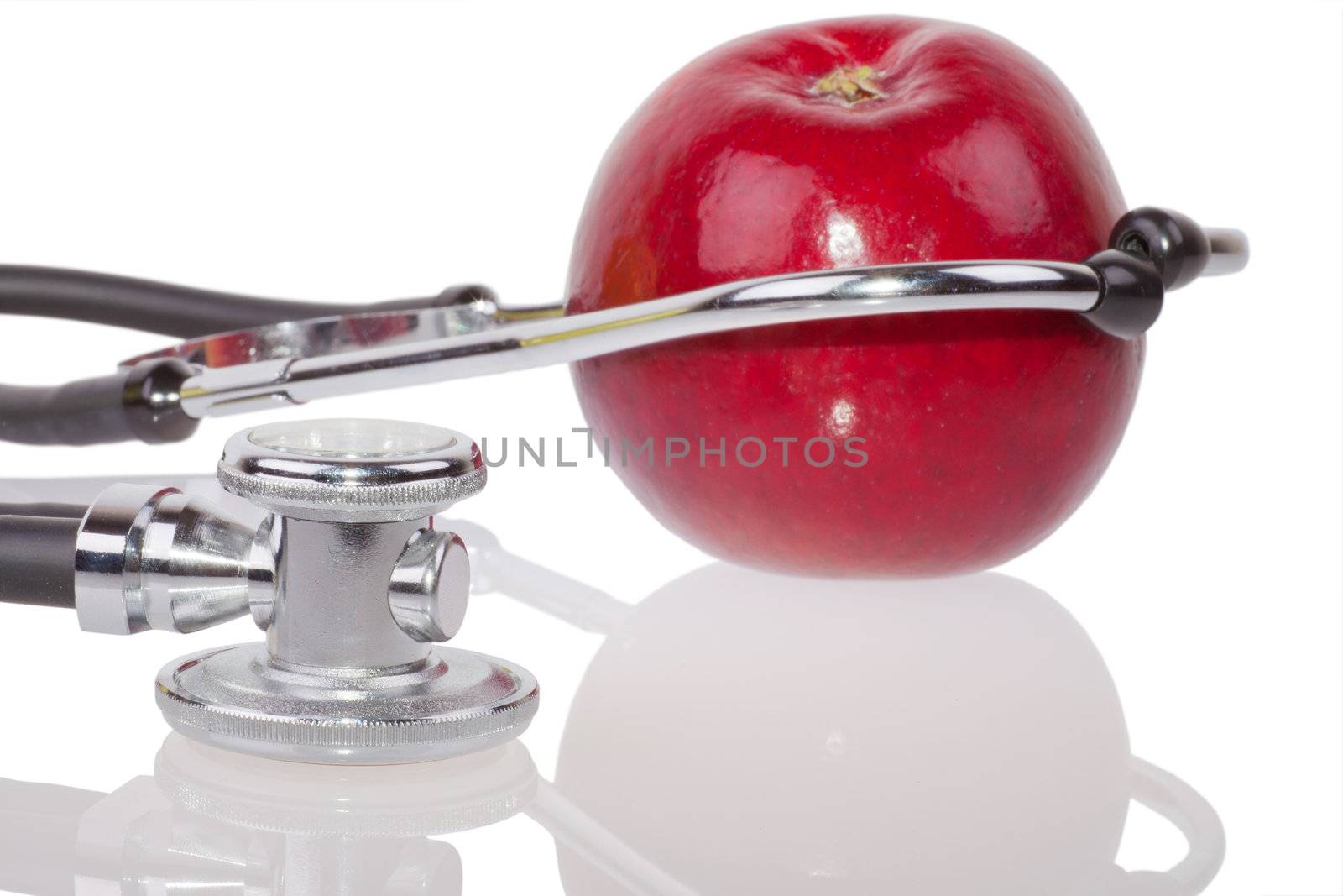 Closeup of apple and stethoscope isolated on white