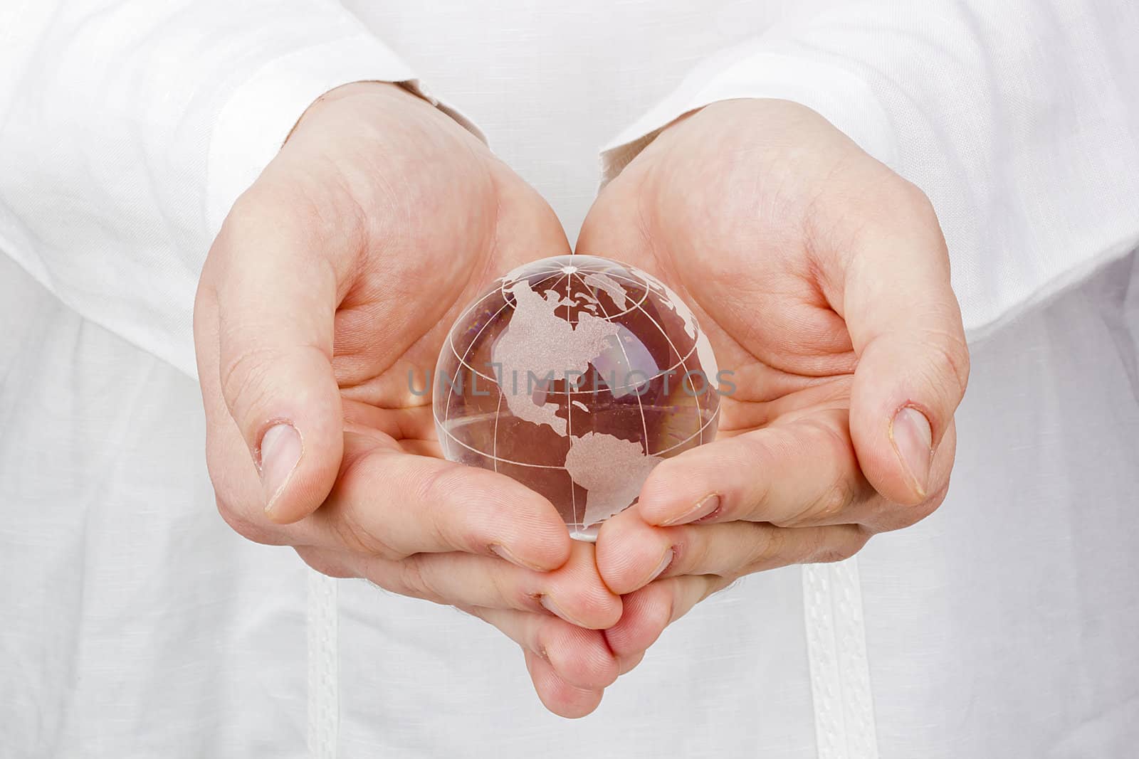Close-up photograph of a glass globe in a man's hands.