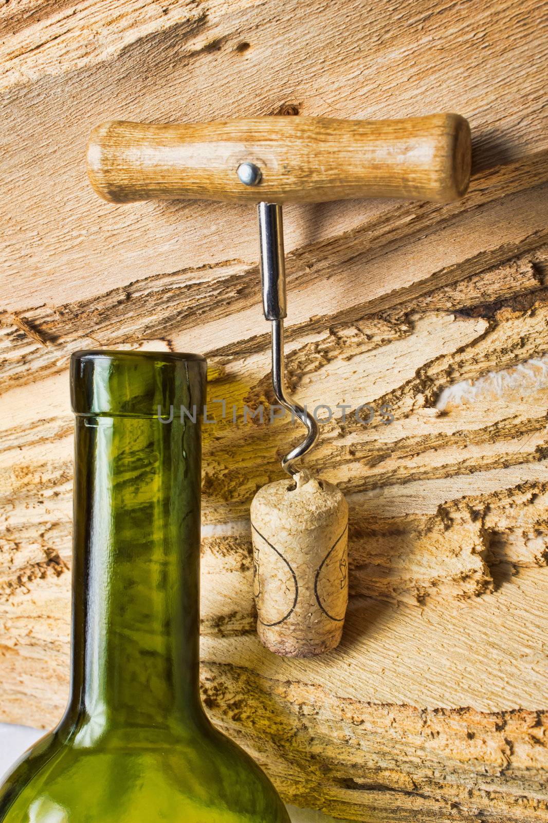 corkscrew with a cork from a bottle on the background texture of the wood